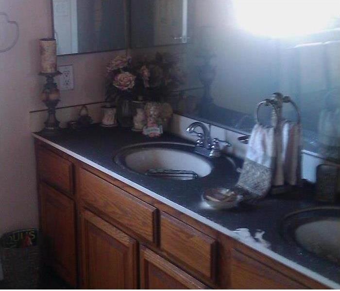 sooty deposits on the counter and mirror and walls in bathroom